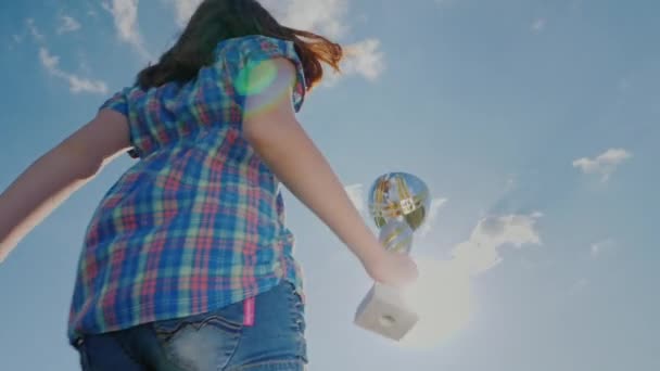 Młoda kobieta o Puchar Mistrzów skacze wysokie nawet w kierunku nieba. On podnosi rękę z kubka. Koncepcja - zwycięstwo sportowe, osiągnięć — Wideo stockowe