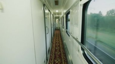 Tren vagonuna yerde bir kapı ile uzun bir koridor. Steadicam atış