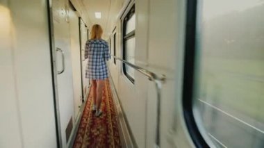 Bir havlu ile bir kadın bir yolcu treni tren yürüyor. Sabah yolda. Steadicam atış