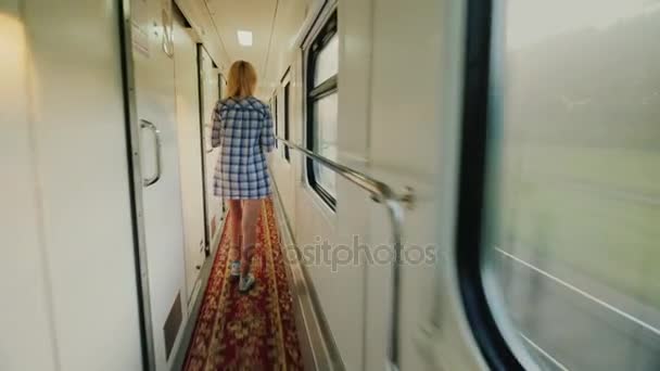 Μια γυναίκα με μια πετσέτα είναι το περπάτημα κατά μήκος το τρένο του μια επιβατική αμαξοστοιχία. Νωρίς το πρωί στο δρόμο. Steadicam βολή — Αρχείο Βίντεο