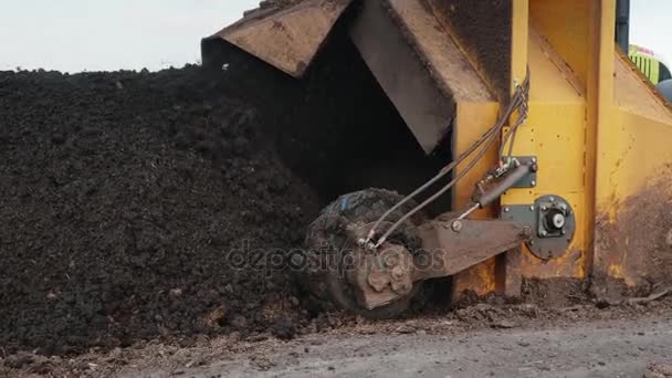 Traktoren produserer lufting av komposten. Blanding av humus og husdyrgjødsel – stockvideo