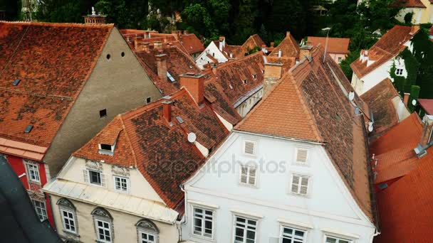 De oude stad van Graz in Oostenrijk. Daken van betegelde daken van huizen met een vidos op de klokkentoren — Stockvideo