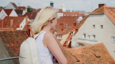 Bir genç kadın turist eski Avrupa şehri bir yükseklikten hayran. Graz, Avusturya. Avrupa'nın turizm. Steadicam atış