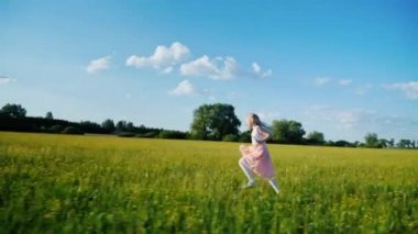 6 yaşında bir kız pembe elbiseli Sarı çiçekli araziyi çalışır. Steadicam atış