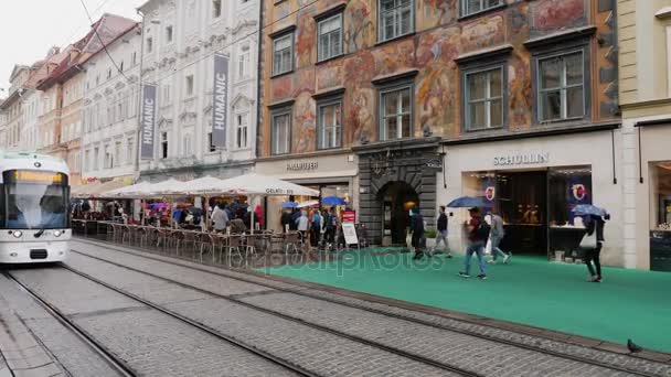 Graz, Oostenrijk, juni 2017: Verkeer van trams en voetgangers op Herrengasse street in regenachtig weer. De stad van Graz in Oostenrijk — Stockvideo