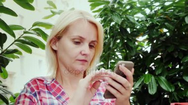 Bir kafede yaz terasında bir akıllı telefon kullanan bir genç kadın portresi. Avrupa - Graz şehrinde Avusturya'nın turizm