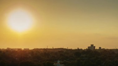 Günbatımı küçük şehir. Ufukta güneş batıyor, evlerin ışıkları yanıyor. Gün gece timelapse için