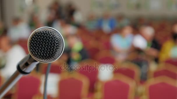 Rack mit Mikrofon. im Hintergrund ein Saal für eine Pressekonferenz — Stockvideo