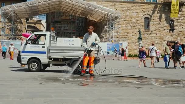 Флоренция, Италия, июнь 2017 года: Рабочий моет улицу в центре Флоренции. Очистка и уборка улиц, приток туристов — стоковое видео