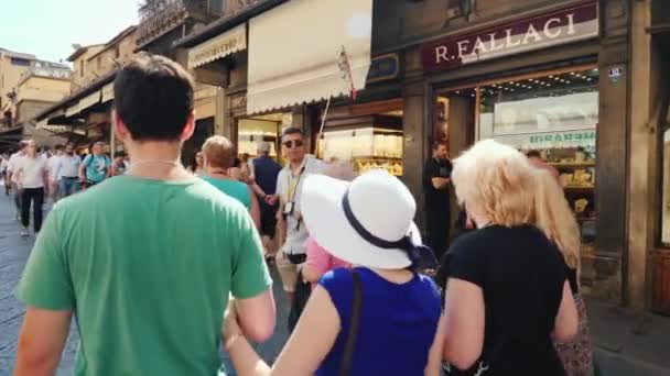 Florence (Italië), juni, 2017: Groep toeristen met een gids op een tour van Florence. Ze lopen langs een mooie straat in de buurt van boetieks en souvenirwinkels — Stockvideo
