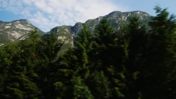 POV video: vackra Alperna i Österrike. Täckt med skog, kan moln ses över topparna. Visa från fönstret i en bil i rörelse — Stockvideo