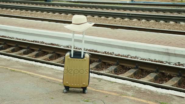 Bolsa de viaje con un sombrero sobre el fondo de un ferrocarril. Concepto - queremos vacaciones, amor para viajar — Vídeo de stock