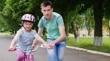 Ağabeyi kız kardeşine bisiklete binmeyi öğretir, çocukların ilk başarıları.