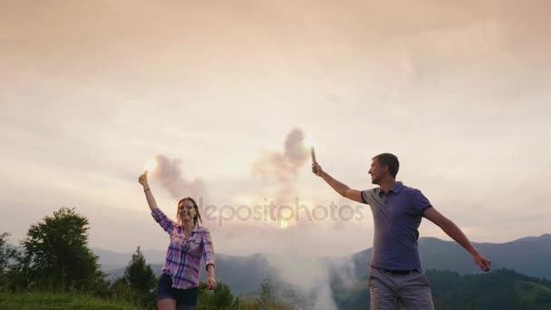 Una pareja joven tiene fuegos artificiales y se divierten. Emocionalmente se regocija, celebra — Vídeo de stock