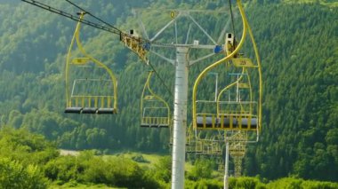 Ski lift insanlar olmadan. Dağlar ve ormanlar, bir açık yaz günü fonunda koltuk taşımak