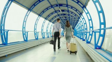 Arka görünümü: iş ortakları - bir erkek ve bir kadın go istasyonu veya Havaalanı terminalinde bagajlı. İş gezisi, takım çalışması