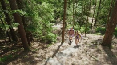 Turist üç arkadaş bir dik dağ yolu tırmanın. Aktif bir şekilde hayatın üstesinden engeller