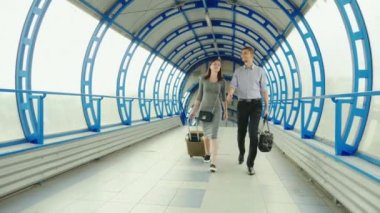 İş ortakları - bir erkek ve bir kadın istasyonu veya Havaalanı terminalinde Bagaj ile gidin. İş gezisi, takım çalışması