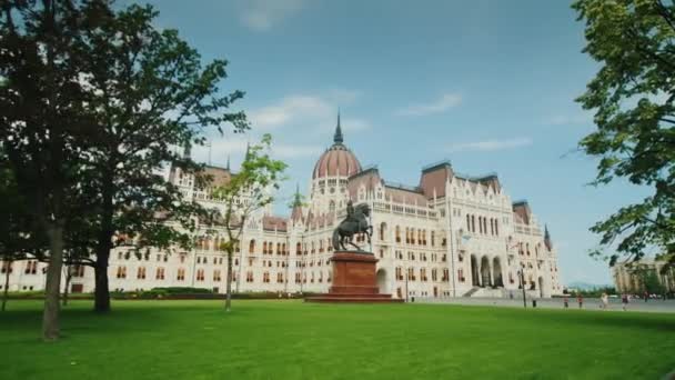 Budapest, Hungría, junio de 2017: Steadicam shot - El edificio del Parlamento húngaro en Budapest - un patio con un hermoso césped . — Vídeo de stock