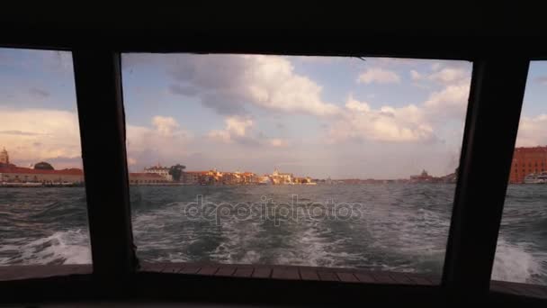 Pohled na Benátky od zádi lodi. Při západu slunce loď pluje od města. — Stock video