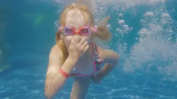 Menina branca de 6 anos aprende a mergulhar na piscina. Vídeo subaquático — Vídeo de Stock