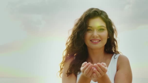 Young woman having fun, blowing on confetti in her palms, smiling. Concept of happy people — Stock Video