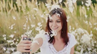 Bir kadın selfie bir yaratıcı fotoğraf çekimleri yapıyor. Her şeyi tüyleriyle mayınları.