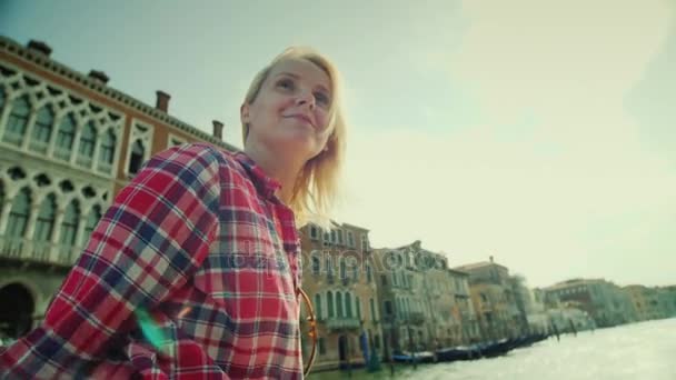 Eine junge frau fährt mit einem wassertaxi auf dem berühmten kanal in venedig. Tourismus in Italien — Stockvideo