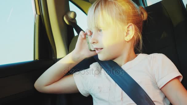 Viajando en el coche. Chica hablando por teléfono, sentado en el asiento trasero de la — Vídeo de stock