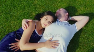 «Ana sayfa» görünümü: bir adam hamile eşi olan yeşil çim üzerinde yalan söylüyor.