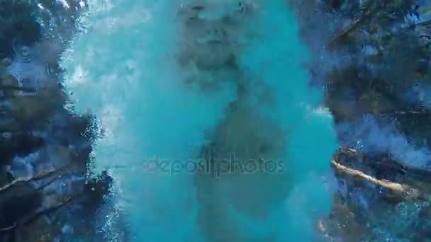 Un homme saute dans la piscine, l'eau bout autour de la caméra. Vidéo sous-marine 