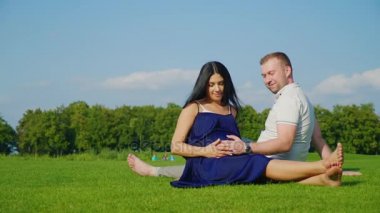 Genç evli çift beklentisiyle bir çocuk. Birlikte onlar parkta çimlere rest