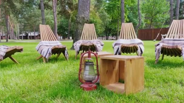 Kostenlose Holzstühle zum Ausruhen. Sie stehen auf einem gepflegten grünen Rasen — Stockvideo