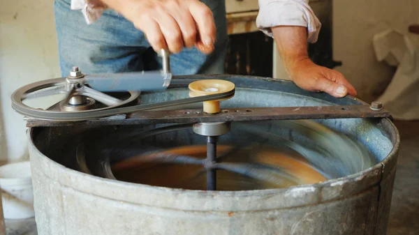 Handarbeit im Bienenhaus. Ein Mann pumpt mit einer Trennmaschine Honig ab — Stockfoto