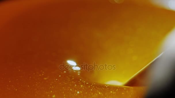 Runder Holzlöffel für Honig, Honig fließt nach unten. auf schwarzem Hintergrund, Hintergrundbeleuchtung — Stockvideo