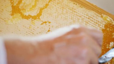 Arıcı bir petek özel bir bıçak ile açılır. Tatlım sonraki pompalama için