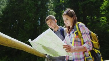 Turizm ve aktif yaşam tarzı. Genç bir çift Haritaya benziyor, bir yaz açık gün pitoresk bir yerde durmak