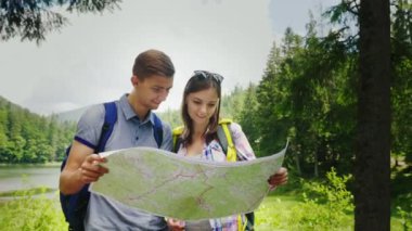 Macera dağlarda. Genç turistler kendi konumu haritaya bakın