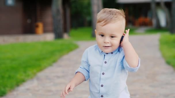 Cool enfant de 1 an joue avec les clés de la voiture. Parle comme au téléphone comme un petit homme d'affaires. Vidéo drôle avec des enfants 