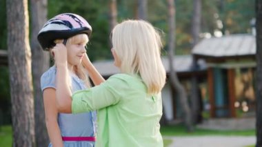 Anne kızı için koruyucu bir kask koyar. Kavram - bakım ve güvenlik
