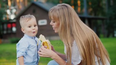Genç anne bir çocuk bir muz ile besleme