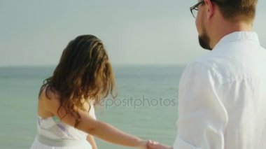 Mutlu kadın kocasıyla kumsalda dans ediyor. Kavram mutlu insanlar