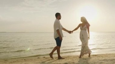 Genç bir çift gün batımında sahilde yürüyor. Bir kadın bir erkek yol açar. Beni kavramı takip