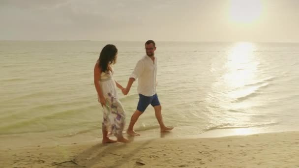 Ρομαντικός περίπατος δίπλα στη θάλασσα στο ηλιοβασίλεμα. Υπάρχει μια εύκολη καλοκαιρινή βροχή. 4 k βίντεο αργής κίνησης — Αρχείο Βίντεο
