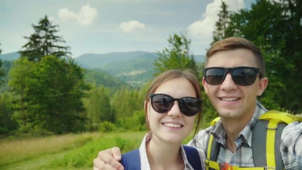 Два путешественника делают селфи в красивой горной местности — стоковое видео