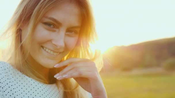 Ritratto di una bella giovane donna al tramonto. Luce arancione mette in evidenza i capelli dietro. Video al rallentatore — Video Stock