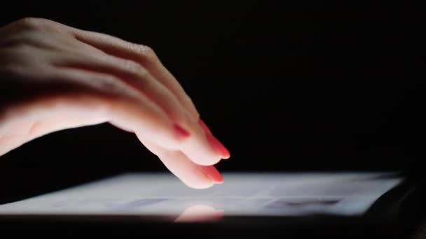 Navegación por Internet en la tableta. Los dedos femeninos desplazan la pantalla de texto, de cerca. Vista lateral — Vídeo de stock