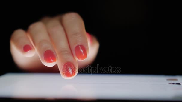 Интернет-просмотр на планшете. Женские пальцы прокручивают текст экрана, крупным планом — стоковое видео