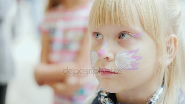 Retrato de uma menina ligeiramente triste com maquiagem em seu rosto — Vídeo de Stock