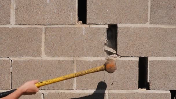 Um grande martelo atinge a parede de tijolos. Quebrando estereótipos. Vídeo em câmera lenta — Vídeo de Stock